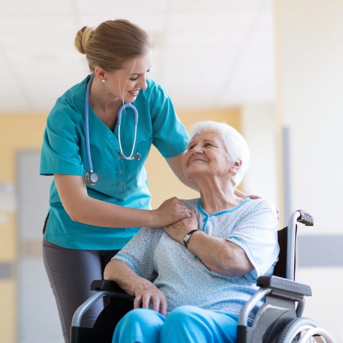 Senior woman in wheelchair with nurse in hospital